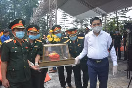 Centre: Inhumation des restes d'une centaine de soldats et experts vietnamiens tombés au Laos