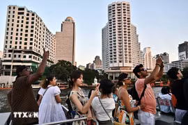 Les touristes font une promenade en bateau sur la rivière Chao Praya à Bangkok, en Thaïlande. Photo : AFP/VNA