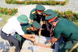 La cérémonie d’inhumation de 11 restes de martyrs volontaires vietnamiens tombés au Laos. Photo : VNA