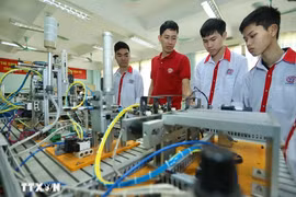 Présentation de modèles d'automatisation aux étudiants de la classe d'électronique industrielle K13 du Collège professionnel de haute technologie de Hanoi. Photo : Hoang Hieu/VNA
