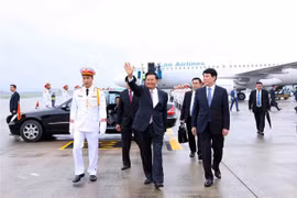 Le secrétaire général du Comité central du Parti populaire révolutionnaire lao (PPRL) et président du Laos, Thongloun Sisoulith, son épouse et une délégation lao de haut rang ont été accueillis à l'aéroport international de Nôi Bài. Photo : 