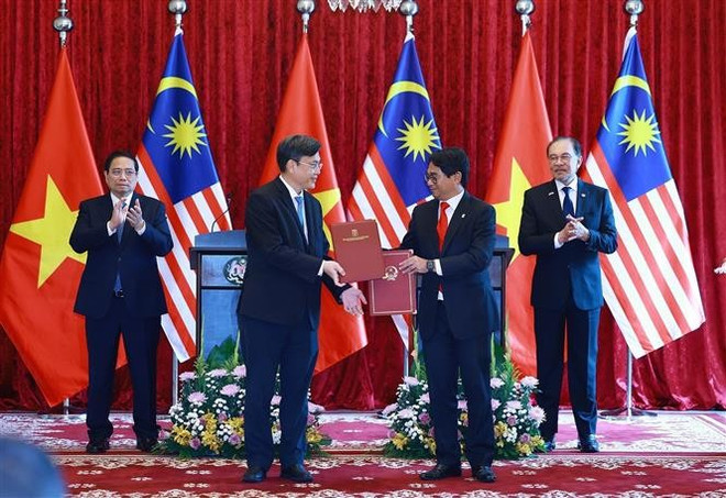 Les deux Premiers ministres asisitent à la cérémonie de signature des documents de coopération entre les deux pays. Photo : VNA 1-1034.jpg