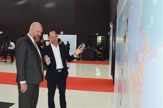 Un représentant d'une entreprise vietnamienne discute avec un partenaire étranger de la zone de libre commerce de Da Nang lors de la cérémonie. Photo : VNA 2-5082.jpg