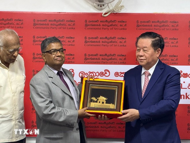 Nguyen Trong Nghia offre un souvenir au secrétaire général du Parti communiste sri-lankais, G. Weerasinghe. Photo . VNA 2.jpg