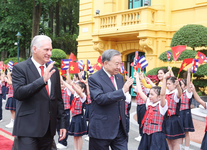 Le secrétaire général du Parti Tô Lâm et le Premier secrétaire et président cubain Miguel Díaz-Canel Bermúdez avec des enfants à Hanoï lors de la cérémonie d'accueil. Photo : VNA don-2.jpg
