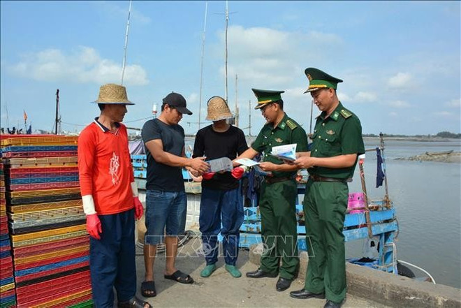 Des agents du poste de garde-frontière de Phuoc Tinh distribuent des dépliants aux pêcheurs pour promouvoir la lutte contre la pêche INN. Photo : VNA 2.jpg