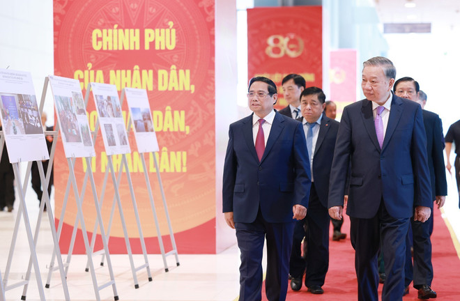Le secrétaire général Tô Lam, le Premier ministre Pham Minh Chinh et des délégués visitent une exposition photographique sur les activités du gouvernement au fil des ans, produite par l'Agence vietnamienne d'information. Photo : VNA cp-2.jpg
