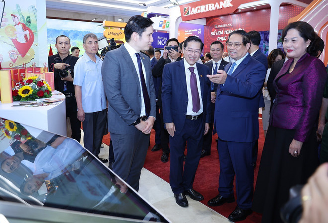 Le Premier ministre Pham Minh Chinh visite l'exposition de produits, services et applications de transformation numérique pour les activités bancaires. Photo : VNA chinh-2.jpg