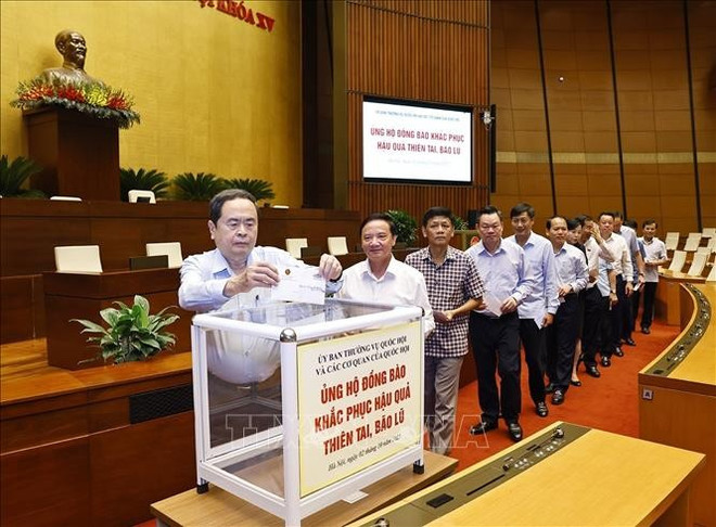 Le président de l'Assemblée nationale, Tran Thanh Man, des cadres et emplyés de l'Assemblée nationale assistent à la collecte de fonds pour soutenir les populations sinistrées. Photo : VNA ung-ho-2.jpg