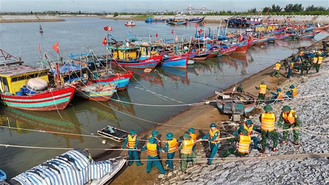 Des forces militaires soutiennent l'ancrage au refuge anti-tempête à Cua Hoi (commune de Dan Hai, province de Ha Tinh). Photo : VNA bao-2.jpg