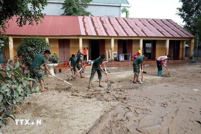 Des officiers et des soldats aident à nettoyer le lycée. Photo : VNA edu-2.jpg
