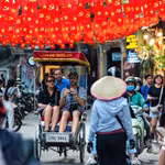 Des touristes internationaux profitent de promenades en cyclo-pousse dans le vieux quartier de Hanoï. Photo znews.vn