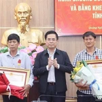 Le président du Comité populaire de la province de Quang Ngai, Nguyên Hoàng Giang, remet la Médaille du Courage du Président de la République à deux citoyens de Ly Son. Photo : VNA