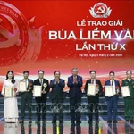 Le secrétaire général du Parti, To Lam, et le Premier ministre Pham Minh Chinh félicitent les lauréats du premier prix. (Photo : VNA)