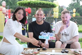 Des touristes découvrent l'art de la dégustation du thé au lotus du lac de l'Ouest, au sein de la Cité impériale de Thang Long à Hanoï. Photo : VNA