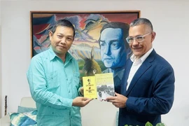 L'ambassadeur vietnamien Vu Trung My (gauche) offre au ministre de la Culture Ernesto Villegas plusieurs œuvres représentatives du Président Hô Chi Minh. Photo: VNA