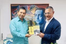 L'ambassadeur vietnamien Vu Trung My (gauche) offre au ministre de la Culture Ernesto Villegas plusieurs œuvres représentatives du Président Hô Chi Minh. Photo: VNA