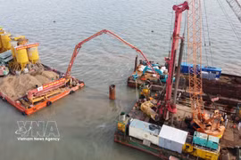 Des ingénieurs et ouvriers travaillent sur le chantier du projet de liaison vers l’île de Hon Khoai. Photo : VNA
