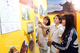 Des jeunes contemplent des oeuvres exposées lors de l'exposition thématique. Photo: VNA