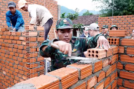 Des officiers et des soldats du commandement de défense de la zone 1 - Son Tinh, relevant du commandement militaire provincial de Quang Ngai, construisent des maisons pour des familles locales. Photo : VNA