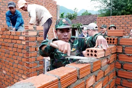 Des officiers et des soldats du commandement de défense de la zone 1 - Son Tinh, relevant du commandement militaire provincial de Quang Ngai, construisent des maisons pour des familles locales. Photo : VNA
