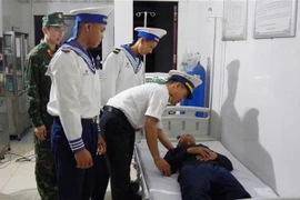 Un médecin du centre médical examine le patient Tieu Viet But. Photo: VNA