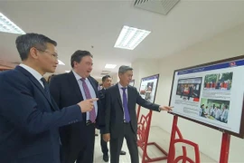 Le vice-ministre de l'Intérieur Cao Huy (gauche) et l'ambassadeur des Etats-Unis au Vietnam Marc Knapper contemplent des photos à l'exposition. Photo: VNA
