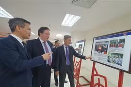Le vice-ministre de l'Intérieur Cao Huy (gauche) et l'ambassadeur des Etats-Unis au Vietnam Marc Knapper contemplent des photos à l'exposition. Photo: VNA