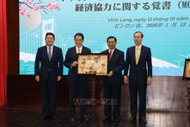 Le secrétaire du comité provincial du Parti de Vinh Long,Tran Van Lau (2e, à droite), remet un cadeau à Tokihiro Nakamura (2e, à gauche), gouverneur de la préfecture japonaise d'Ehime. Photo : Pham Minh Tuan - VNA.