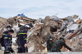 Les secouristes vietnamiens s'efforcent de chercher des victimes sous les décombres. Photo : VNA