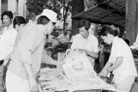 Des habitants de la capitale achètent le « Journal de l'après-midi » de VNA pour suivre les nouvelles de la clôture du 7e Congrès national du Parti (17 juillet 1991). Photo : VNA