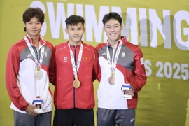 Le nageur Pham Thanh Bao (au milieu) remporte la médaille d'or du 200 m brasse messieurs. Photo : VNA