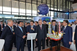 Le secrétaire général To Lam, le Premier ministre Pham Minh Chinh et d'autres dirigeants du Parti et de l'État visitent l'exposition scientifique et technologique marquant le 50e anniversaire de la création de Petrovietnam. Photo: VNA