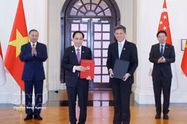 Le secrétaire général du Parti communiste du Vietnam et président de la République, To Lam, et le Premier ministre singapourien, Lawrence Wong, assistéent à la cérémonie de remise et d’annonce de documents de coopération. Photo: VNA