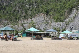 Des touristes étrangers à la plage de Tùng Thu, district de Cat Ba. Photo: VNA