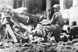 Le soldat Tran Thanh brandit une bombe à trois pointes, prêt à détruire les chars d'ennemis dans les rues d'Hanoï le 23 décembre 1946 – au début de la guerre de résistance nationale. Photo : Archives 