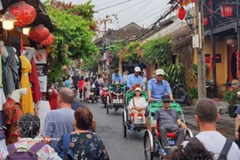 Touristes vietnamiens et étrangers à Hoi An. Photo : VNA