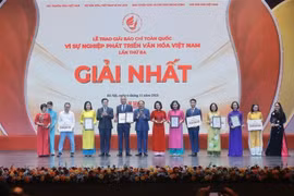 Le vice-Premier ministre Mai Van Chinh (4e, gauche) et le ministre de la Culture, des Sports et du Tourisme, Nguyen Van Hung (6e, gauche), remettent le premier prix aux auteurs et aux groupes d'auteurs lauréats. Photo : VNA