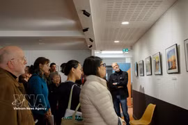 Des visiteurs contemplent les photos exposées. Photo: VNA