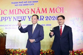 Tran Luu Quang (à gauche), membre du Bureau politique et secrétaire du Comité du Parti de Hô Chi Minh-Ville, à la rencontre. Photo : VNA