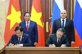Les Premiers ministres vietnamien Pham Minh Chinh (gauche, 2e ligne) et russe Mikhaïl Michoustine (droite, 2e ligne) assistent à la signature de l'accord de coopération pour la construction d'une centrale nucléaire au Vietnam. Photo : VNA