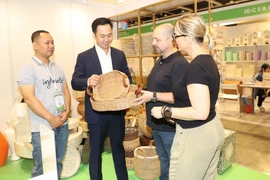 Des clients internationaux découvrent l'artisanat vietnamien. Photo : Xuan Vinh/VNA