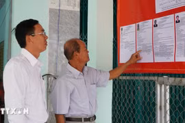 Des électeurs consultent les brèves biographies des candidats au Conseil populaire de la commune de Tan Hong, province de Dong Thap, mandat 2026-2031. Photo : VNA