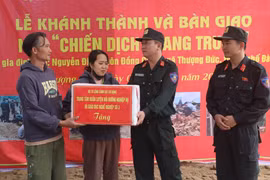 Le général de division Pham Hong Phuc (à droite), du commandement de la police mobile, félicite la famille de Nguyen Dinh, commune de Thuong Duc, pour leur nouvelle maison. Photo : VNA