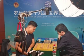 Le roi vietnamien du xiangqi, Lai Ly Huynh (gauche), remporte son premier titre mondial dans cette discipline en dominant le Chinois Yin Sheng lors de la finale du Championnat du monde de xiangqi 2025. Photo: VXF/chinhphu.vn