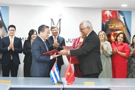 Le ministre vietnamien de la Justice, Nguyen Hai Ninh (gauche) et son homologue cubain, Oscar Manuel Silvera Martínez, signent un accord portant sur un projet d'assistance technique destiné au ministère cubain de la Justice. Photo: VNA