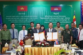 Le vice-président du Comité populaire provincial, Le Trung Ho (à gauche) et Khiev Rithiphorn, vice-gouverneur de la province de Kampot, signent un accord sur la mise en œuvre de l'accord commercial frontalier Vietnam-Cambodge. Photo : VNA