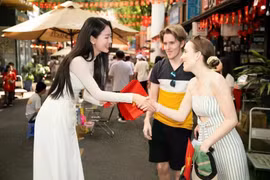 Des touristes internationaux reçoivent des cadeaux de la part de leurs amis vietnamiens. Photo : VietnamPlus