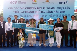 Lors de la cérémonie d'accueil, le comité d'organisation a offert des fleurs et des cadeaux à trois heureux invités du vol VN337 Osaka-Da Nang. Photo : VNA