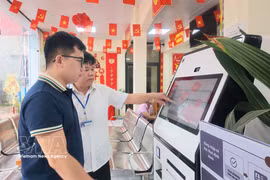 Des agents du Centre de services administratifs publics de la commune de Chi Lang, dans la province de Lang Son, guident les habitants dans l'utilisation du KIOSK de services publics assisté par l'intelligence artificielle (IA). Photo : VNA
